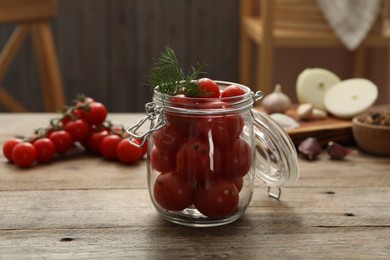 Pickling jar with fresh tomatoes on wooden kitchen table
