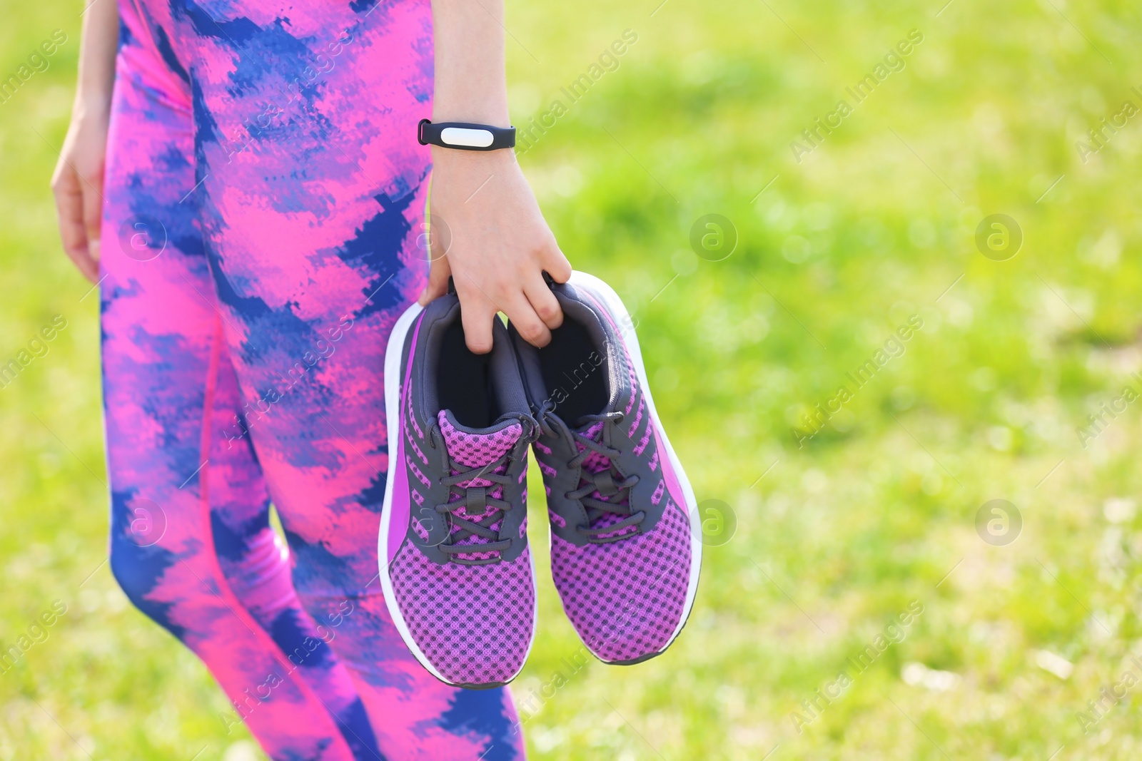 Photo of Young woman with training shoes outdoors, closeup