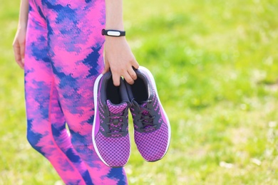 Photo of Young woman with training shoes outdoors, closeup