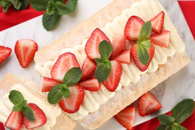 Photo of Delicious cake roll with strawberries and mint on white table, flat lay