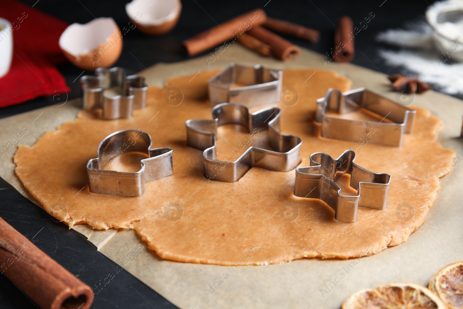 Photo of Making homemade Christmas cookies. Dough and cutters on table, closeup