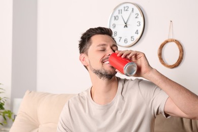 Photo of Handsome man drinking beverage on sofa indoors