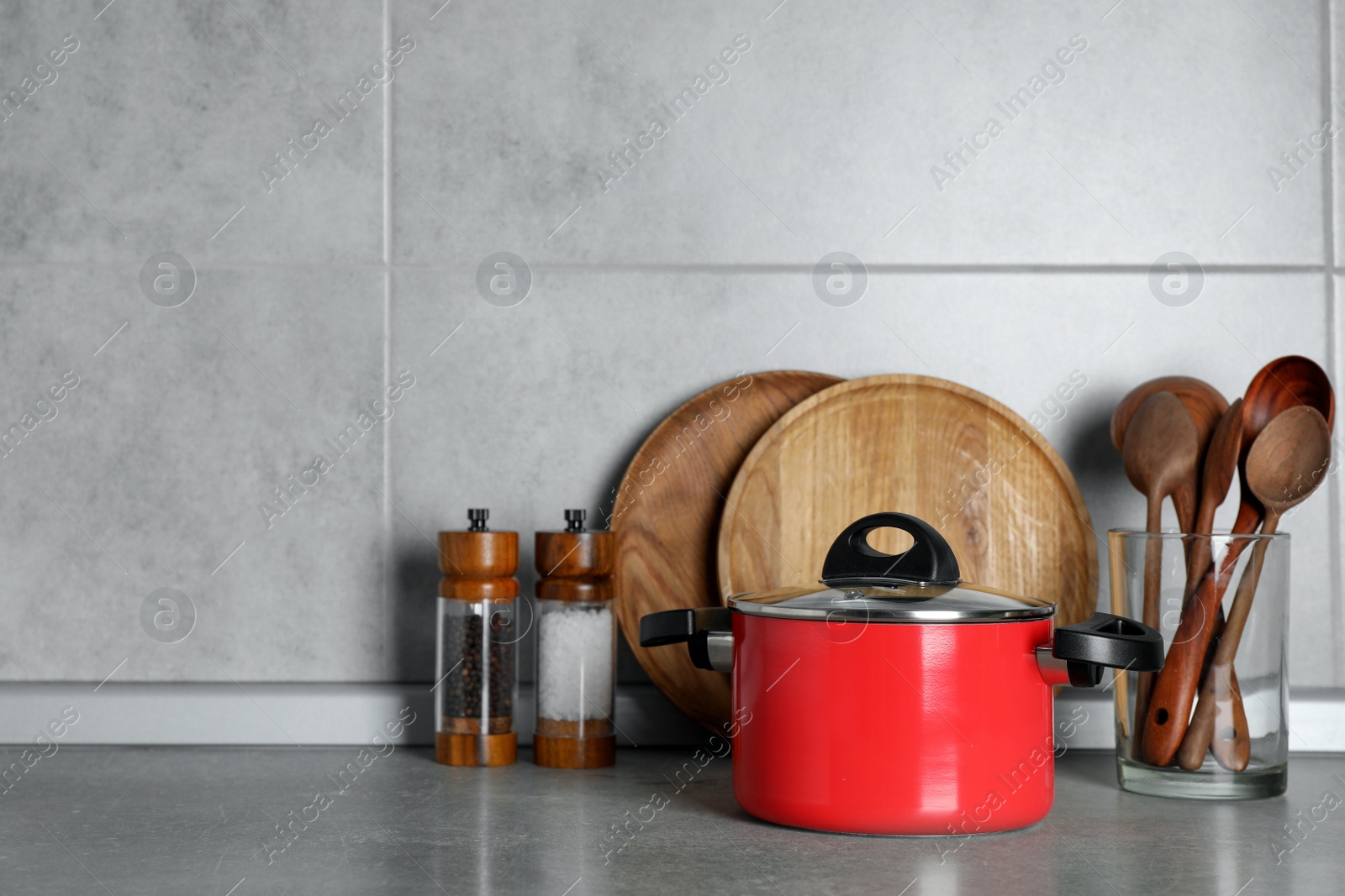 Photo of Set of different cooking utensils on grey countertop in kitchen. Space for text