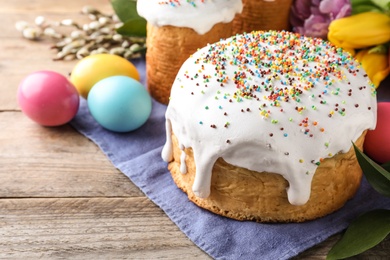 Photo of Beautiful Easter cake and painted eggs on wooden table