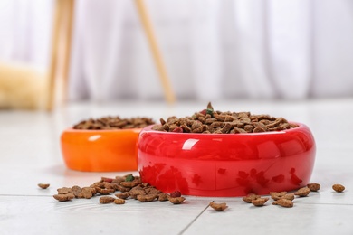 Bowls with food for cat and dog on floor. Pet care