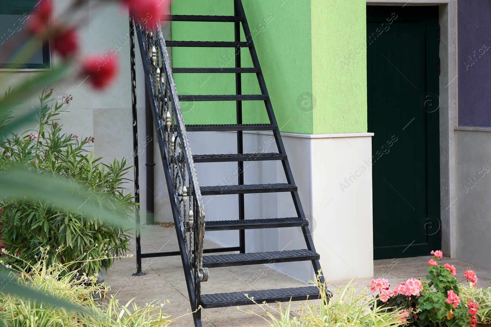 Photo of Stylish metal stairs with railings near building on sunny day