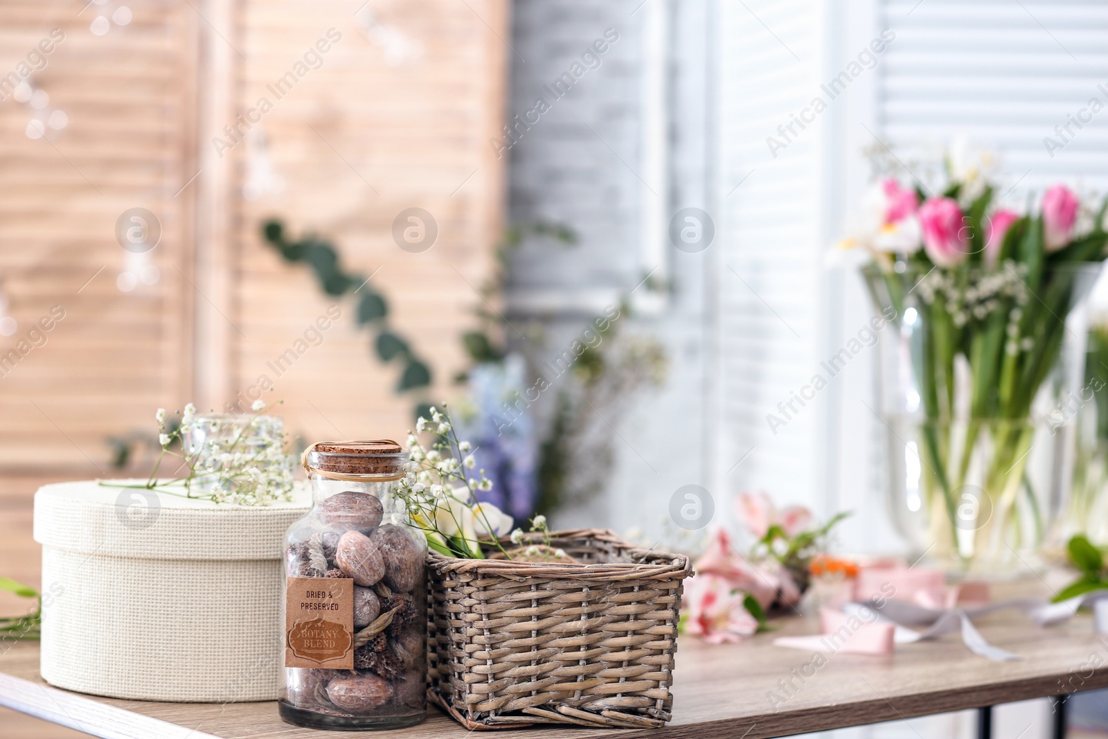 Photo of Decorator's workplace with beautiful flowers on table