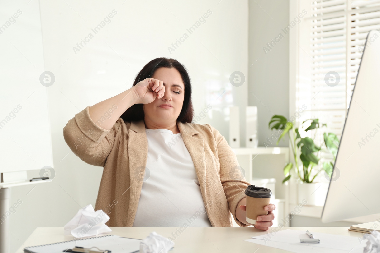 Photo of Lazy overweight worker at white desk in office