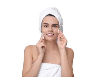 Young woman cleaning her face with cotton pads on white background