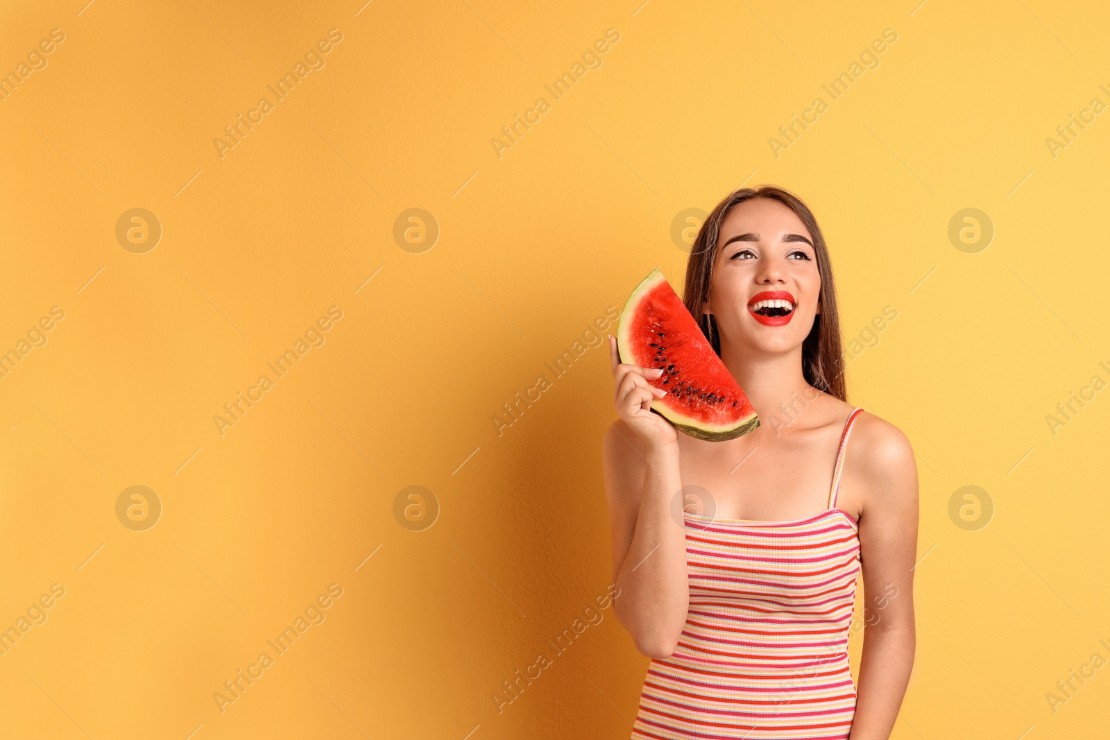 Photo of Beautiful young woman posing with watermelon on color background