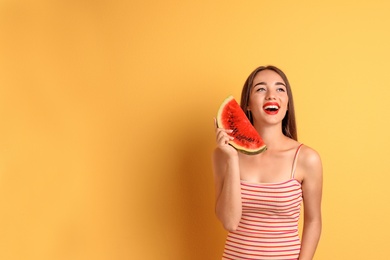 Beautiful young woman posing with watermelon on color background