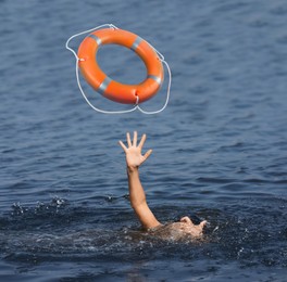 Image of Drowning woman with raised hand getting lifebelt in sea, closeup