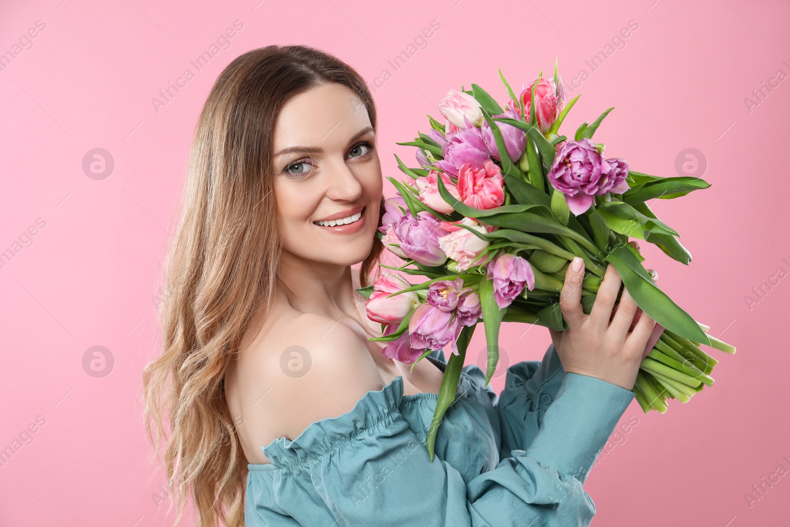 Photo of Happy young woman with bouquet of beautiful tulips on pink background