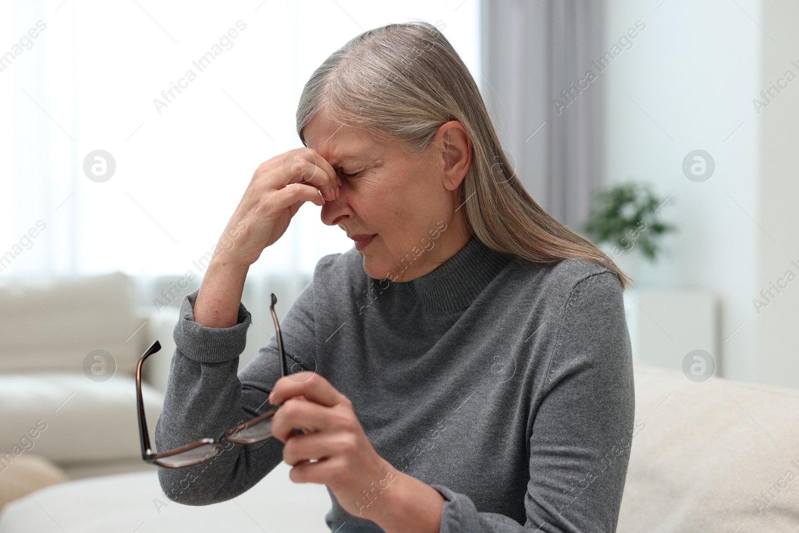 Photo of Overwhelmed woman with glasses suffering at home
