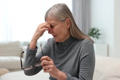 Overwhelmed woman with glasses suffering at home