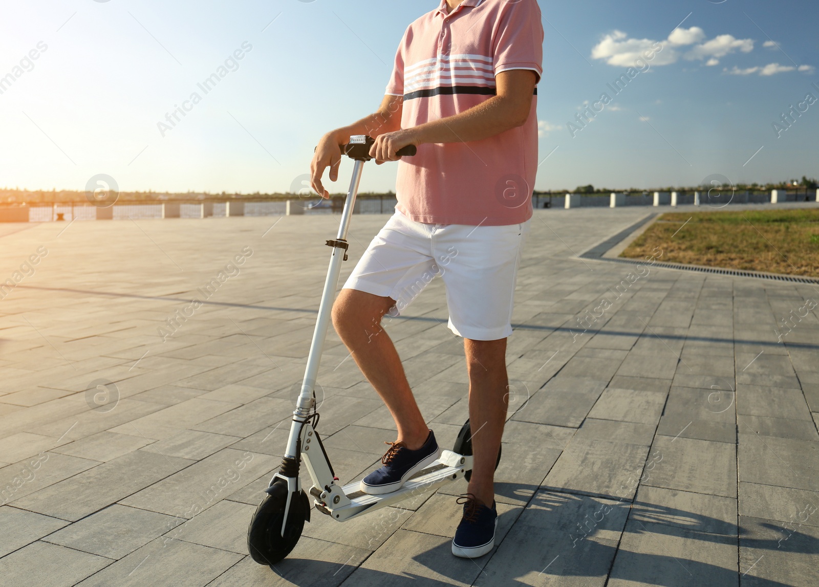 Photo of Man with modern kick scooter on waterfront, closeup