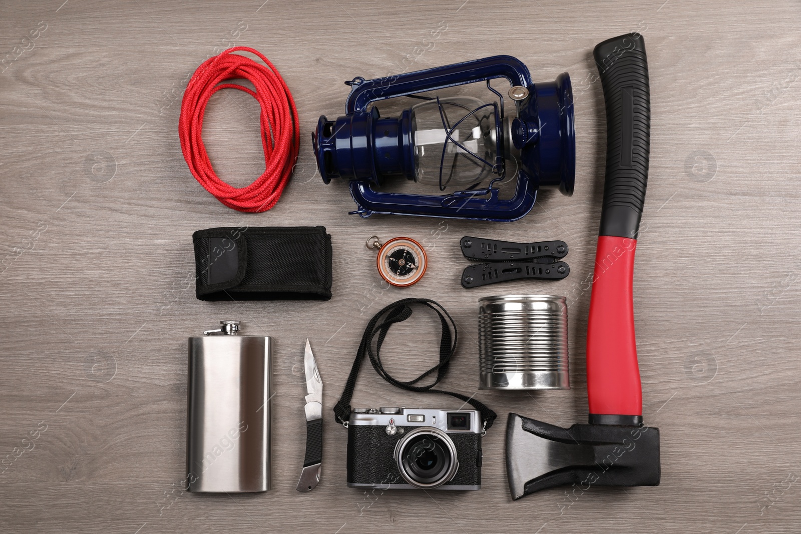 Photo of Flat lay composition with different camping equipment on wooden background