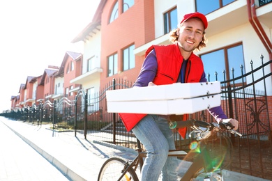 Male courier on bicycle delivering food in city