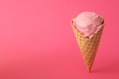 Delicious ice cream in waffle cone on pink background. Space for text