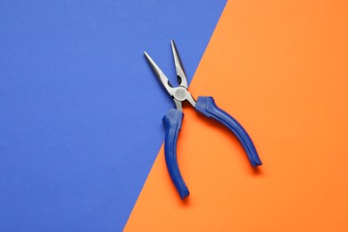 Photo of Needle nose pliers on color background, top view
