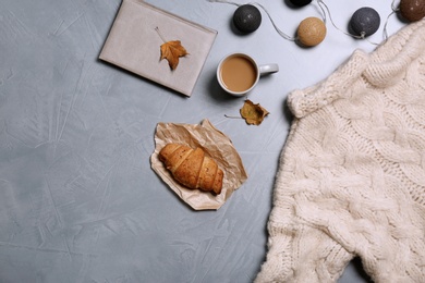 Photo of Flat lay composition with warm sweater and space for text on color background