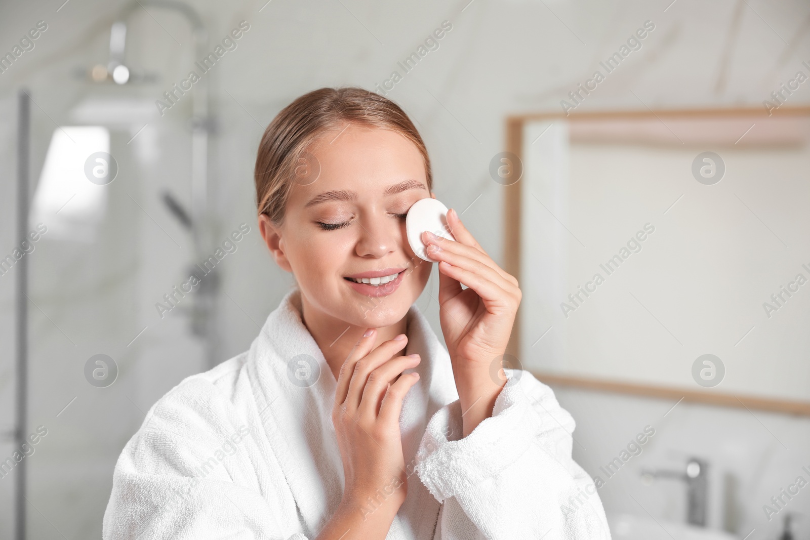 Photo of Beautiful young woman with cotton pad indoors