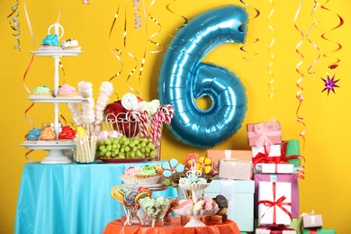 Photo of Dessert table in room decorated with blue balloon for 6 year birthday party