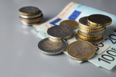 Photo of Euro banknotes and coins on light table, closeup