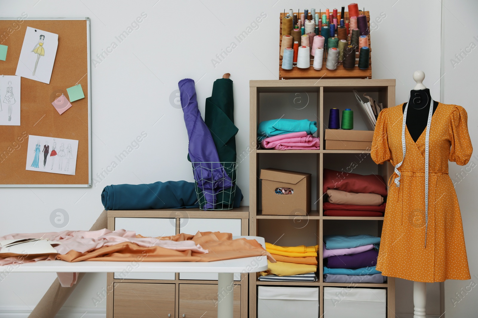 Photo of Dressmaking workshop interior with collection of different fabrics and threads