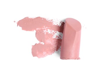 Nude color lipstick and smear on white background, top view