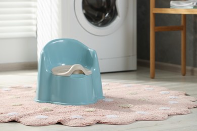 Light blue baby potty on rug indoors. Space for text