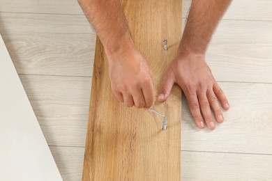 Photo of Man with hex key assembling furniture on floor, above view