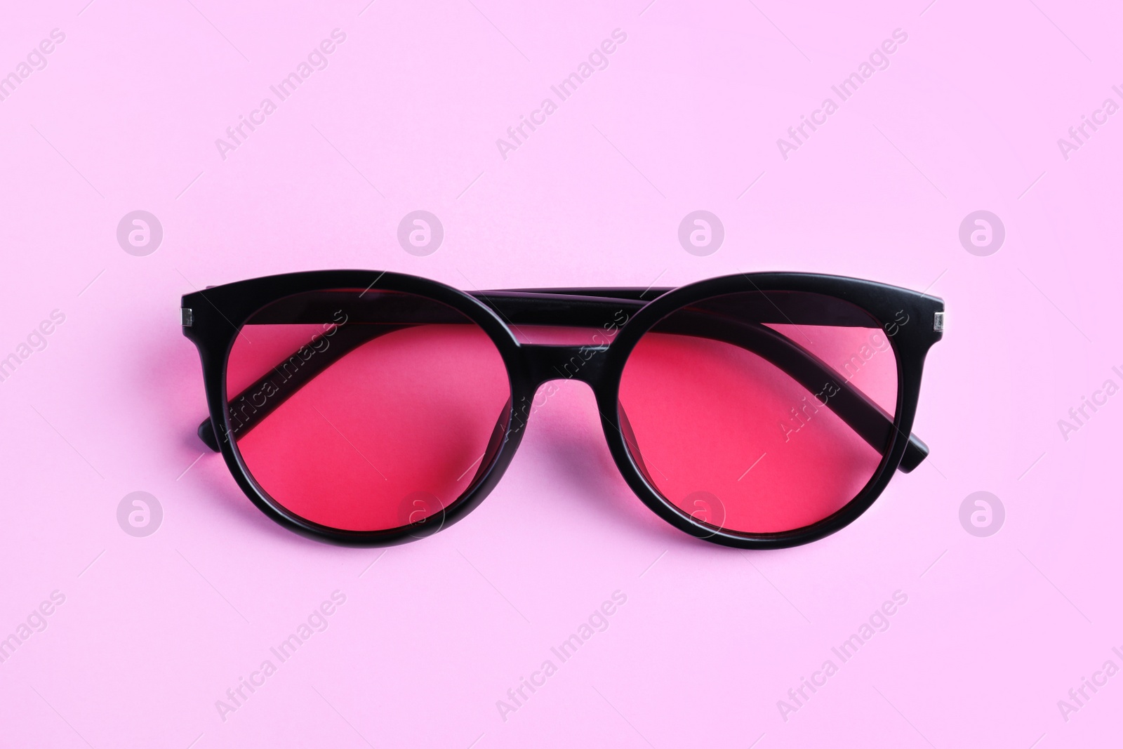 Photo of Stylish sunglasses on light violet background, top view