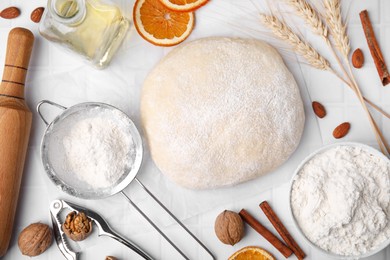 Fresh dough and ingredients on white tiled table, flat lay