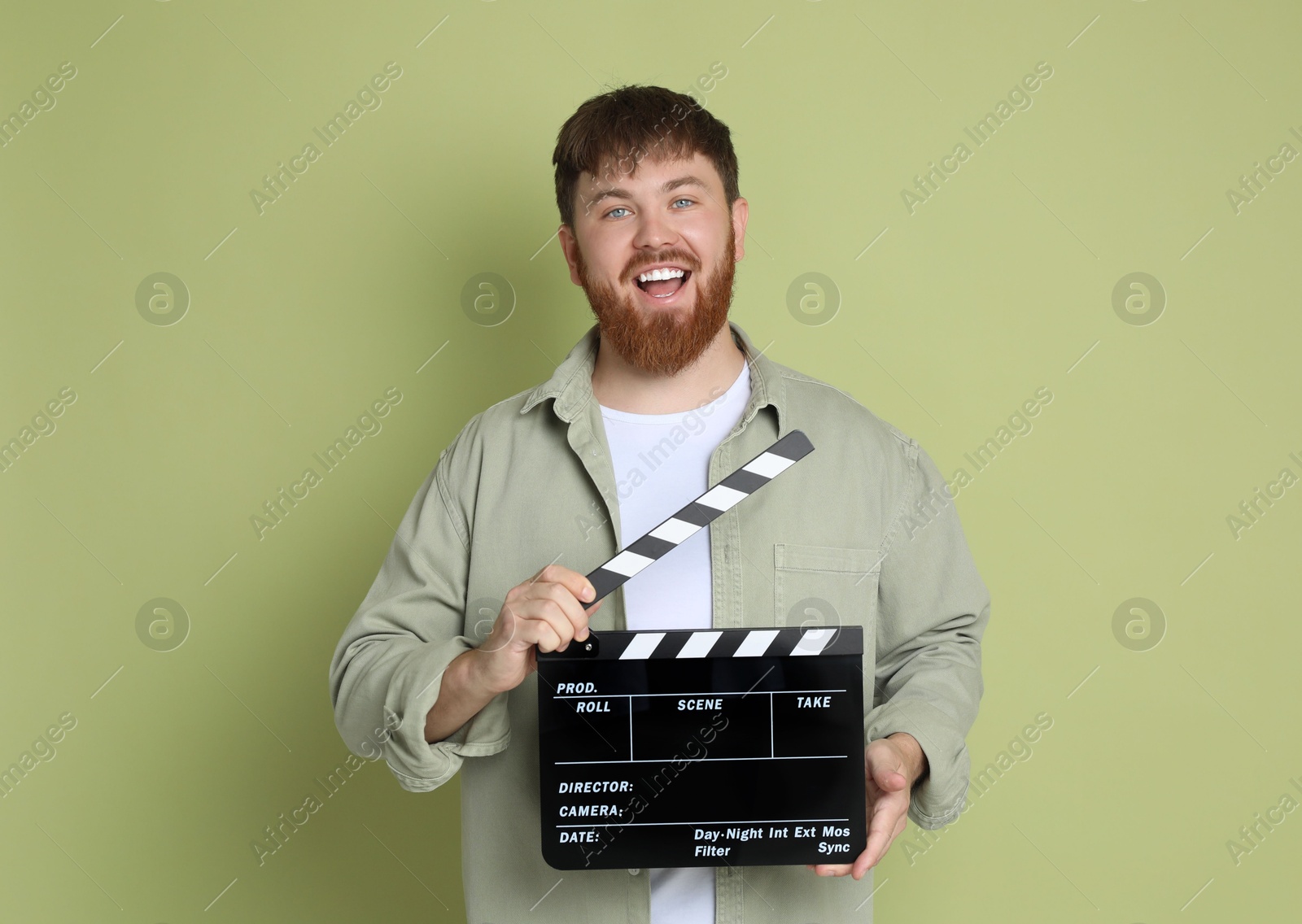 Photo of Making movie. Smiling man with clapperboard on green background