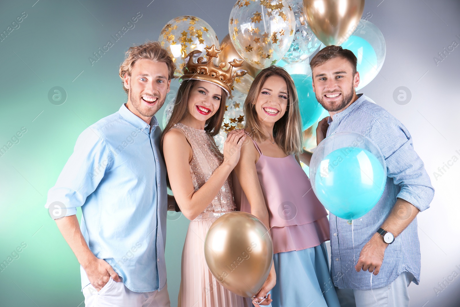 Photo of Friends with air balloons on color background