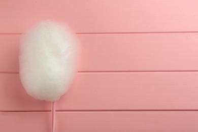 Photo of One sweet cotton candy on pink wooden table, top view. Space for text