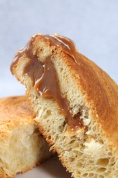 Photo of Supreme croissant with chocolate paste and nuts on light background, closeup. Tasty puff pastry