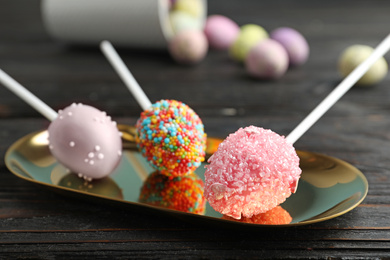 Photo of Delicious sweet cake pops on black wooden table. Easter holiday