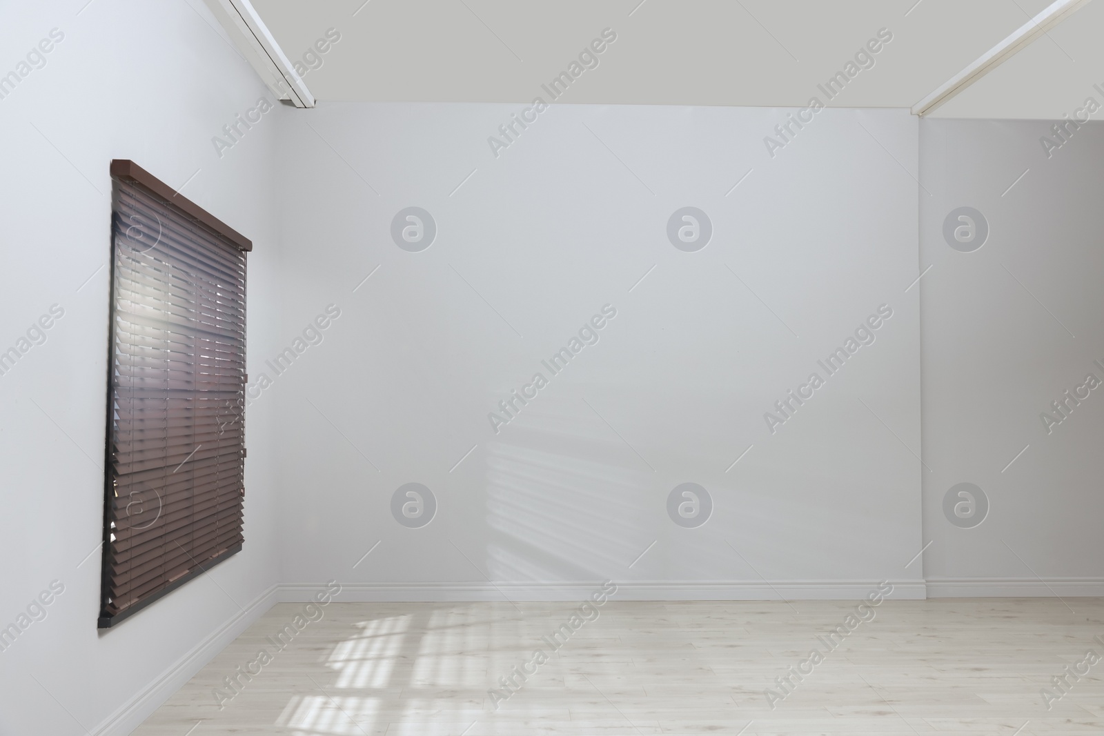 Photo of Empty room with white walls, large window and wooden floor