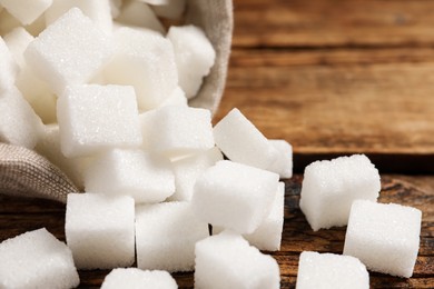 Photo of Refined sugar cubes on wooden table, closeup