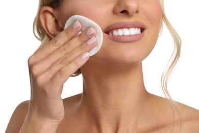 Smiling woman removing makeup with cotton pad on white background, closeup