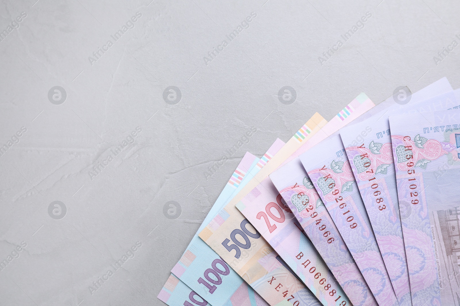 Photo of Ukrainian money on grey background, flat lay. Space for text