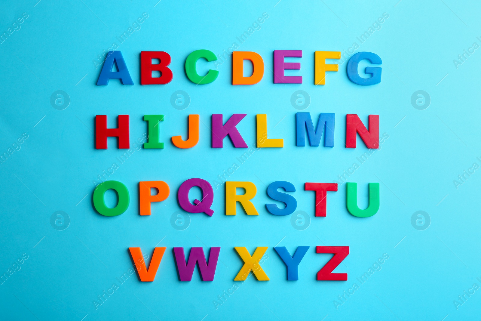 Photo of Colorful magnetic letters on blue background, flat lay. Alphabetical order