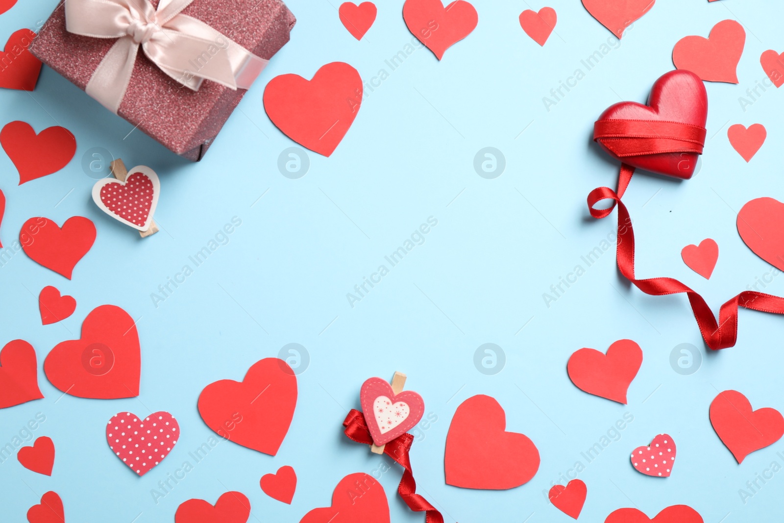 Photo of Flat lay composition with red hearts and gift on light blue background. Space for text