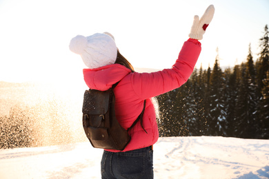 Photo of Young woman having fun outdoors on snowy winter day