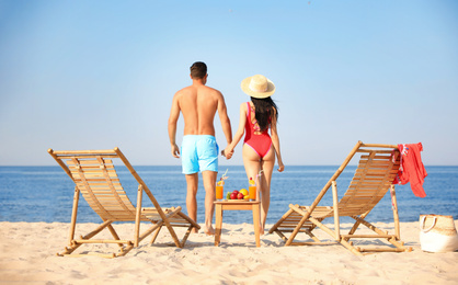 Photo of Couple resting on sunny beach at resort