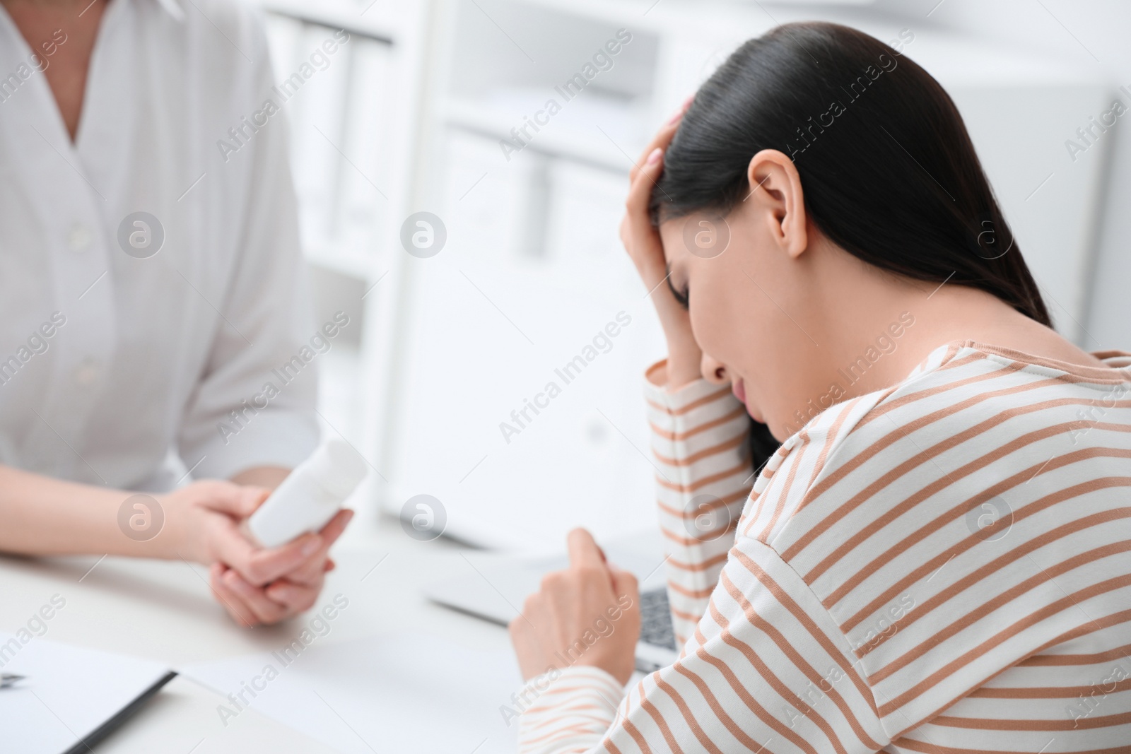 Photo of Young woman suffering from migraine in hospital