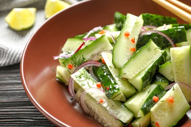 Photo of Delicious cucumber salad with onion on plate, closeup