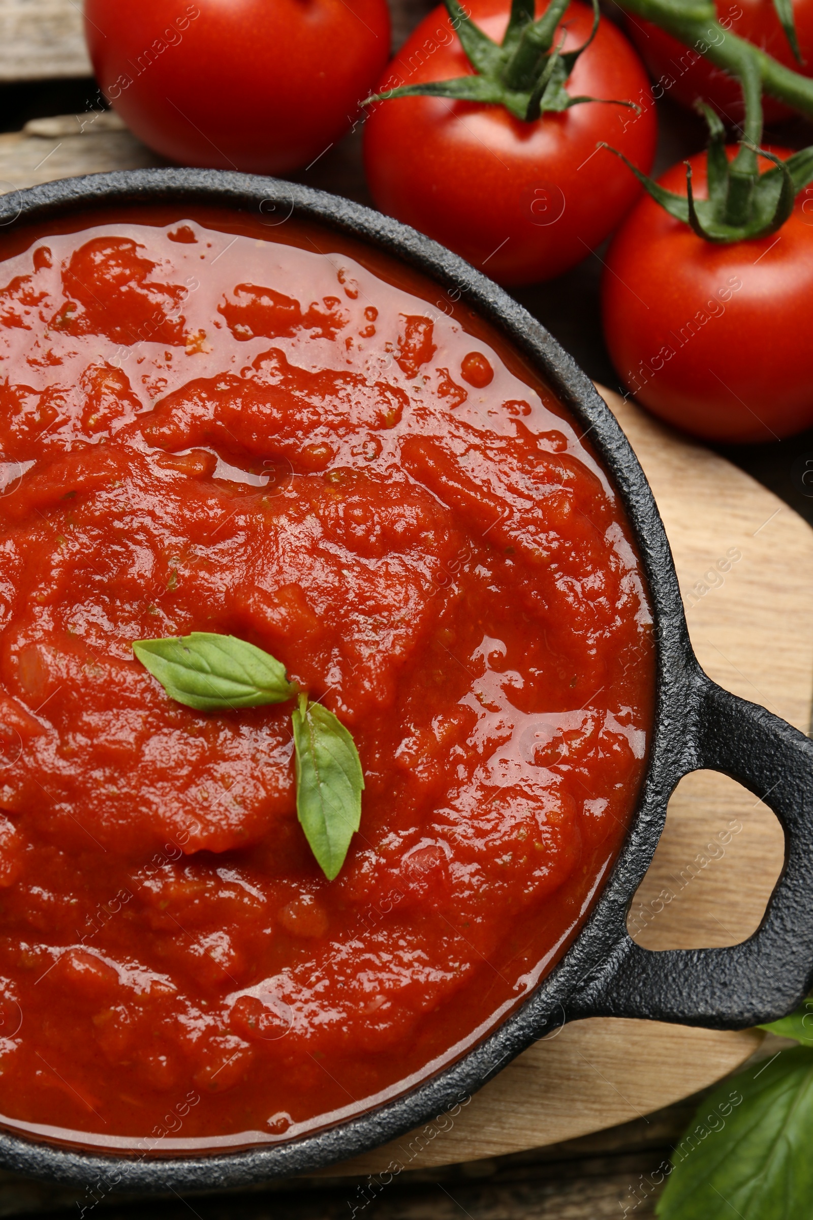 Photo of Homemade tomato sauce in bowl and fresh ingredients on table, flat lay